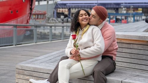 a happy guy kissing a girl