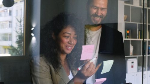 a happy girl writing on a paper slip for her partner