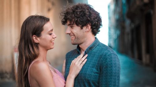 a woman and man standing close and smiling