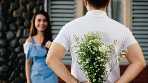 guy holding flowers for the girl