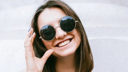 a smiling girl with black specs