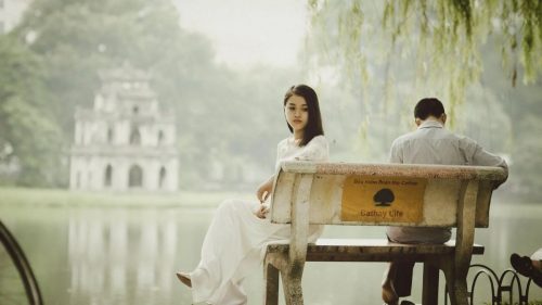 girl facing away from his boyfriend in a park bench