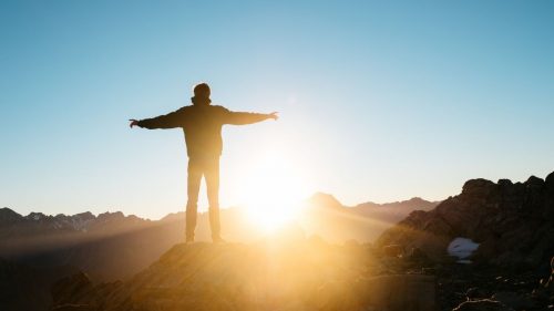 a man facing sunrise