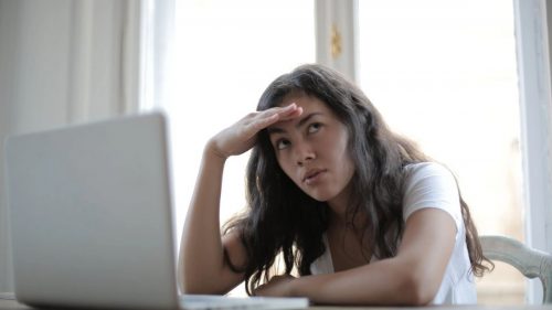 a tense girl sitting in front of laptop