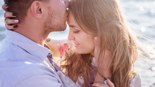 boy kissing his girlfriend's forehead