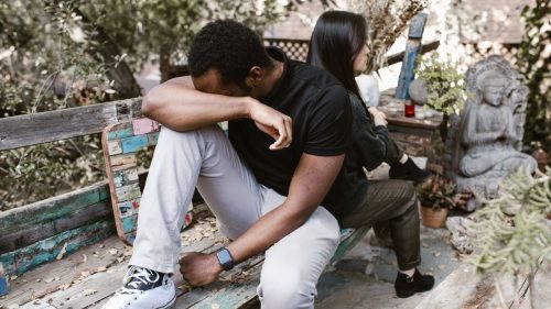 a man and woman sitting with backs towards each other